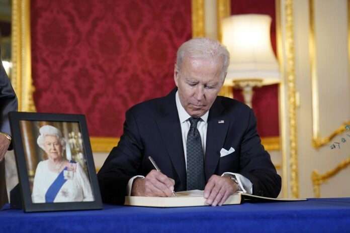 President Joe Biden signs a book of condolence Biden