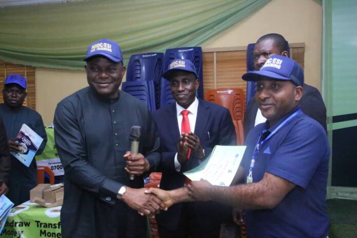 The NDDC Acting Managing Director, Engr. Emmanuel Audu-Ohwavborua, (left) presenting a certificate to one of the participants, Mr. Paul Ijeh, (right) during the graduation ceremony of the NDDC/ESI Entrepreneurial Development Scheme, in Port Harcourt. In the middle is the NDDC Director Commercial and Industrial Development, CID, Mr. Messiah Obuzor